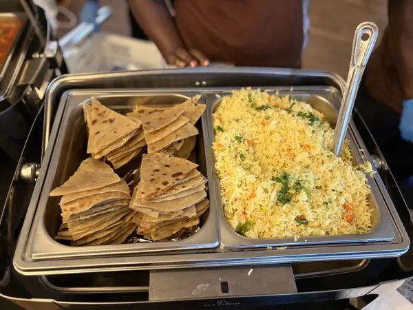 Pilau rice and folded chapati in a chafing dish